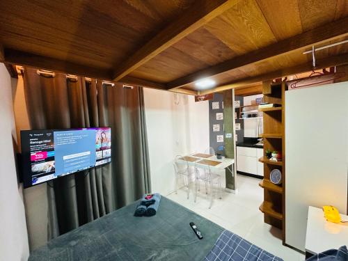 a room with a large window with a tv on the wall at Loft encantador D - 8 km de Floripa in São José