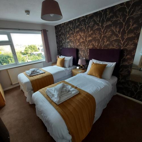 a hotel room with two beds and a window at The Kenbury B&B in Shanklin