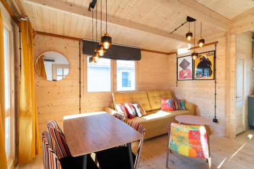 a living room with a couch and a table at Wojtek - domki letniskowe i pokoje, animacje, melex na plażę in Dziwnów