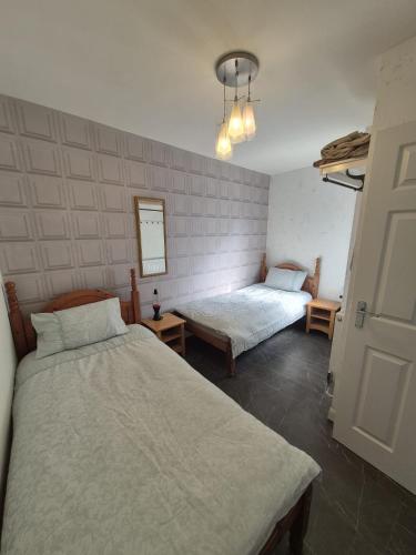 a bedroom with two beds and a mirror at Ulverston Town Centre Flat (2 Bedrooms) in Ulverston