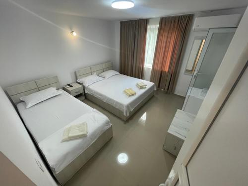 a hotel room with two beds and a mirror at Cazare Pedro in Mamaia