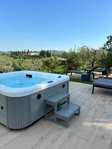 a hot tub sitting on a deck with a bench at Podere La Quercia in San Gimignano