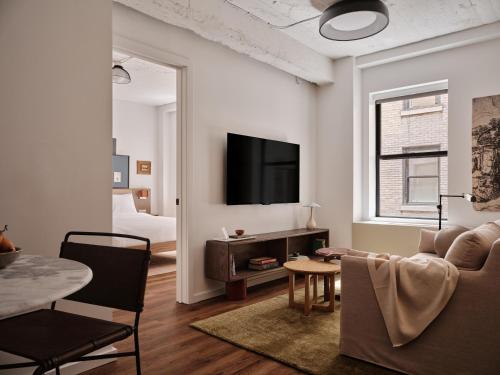 a living room with a couch and a tv at Mint House Washington DC - Downtown in Washington