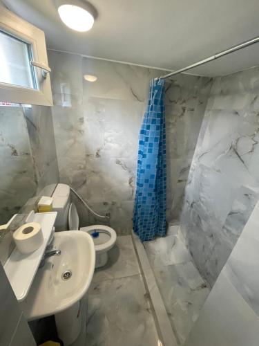 a bathroom with a toilet and a sink and a shower at Cazare Pedro in Mamaia