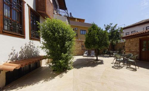 a patio with a table and chairs next to a building at Minyon Hotel in Antalya