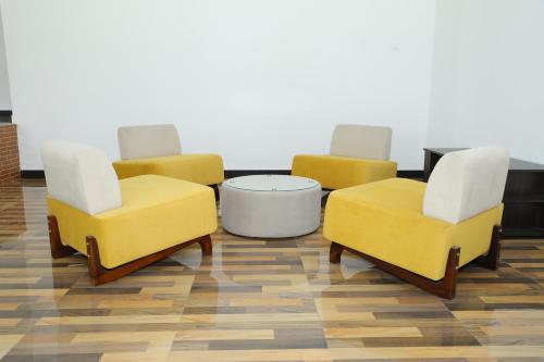 three yellow chairs and a coffee table in a room at Palmyra Resort Jaffna in Jaffna