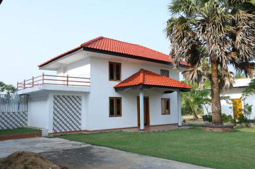 a white house with an orange roof at Palmyra Resort Jaffna in Jaffna