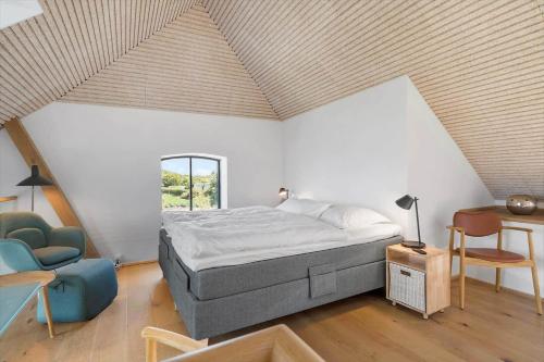 a bedroom with a bed and a table and a chair at 1174-Ringkobing-Jagtvej-34-C-lejl-5 in Ringkøbing