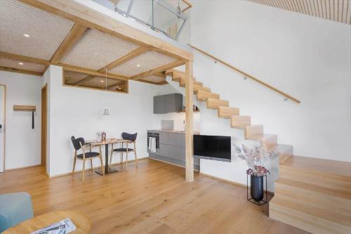 a living room with a staircase in a loft at 1174-Ringkobing-Jagtvej-34-C-lejl-5 in Ringkøbing