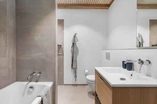 a bathroom with a tub and a sink and a toilet at 1174-Ringkobing-Jagtvej-34-C-lejl-5 in Ringkøbing