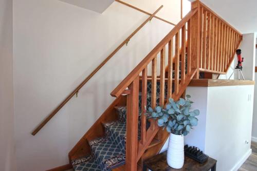 a wooden staircase with a vase with a plant at Dream Stratton Forest Cabin with Hot Tub and Fast WiFi in Stratton