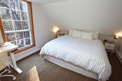 a bedroom with a white bed and a window at Dream Stratton Forest Cabin with Hot Tub and Fast WiFi in Stratton