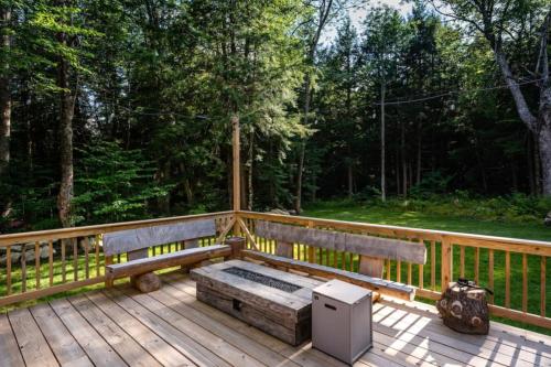 a wooden bench sitting on a wooden deck at Dream Stratton Forest Cabin with Hot Tub and Fast WiFi in Stratton