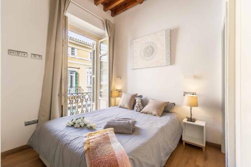 a bedroom with a large bed and a window at Top-Class Larios Executive Suite - Malaga Center in Málaga