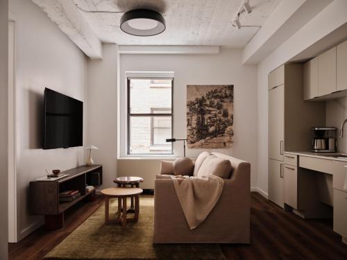 a living room with a couch and a tv at Mint House Washington DC - Downtown in Washington