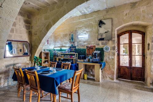 a dining room with a blue table and chairs at Serene Escape Farmhouse B&B in San Katald