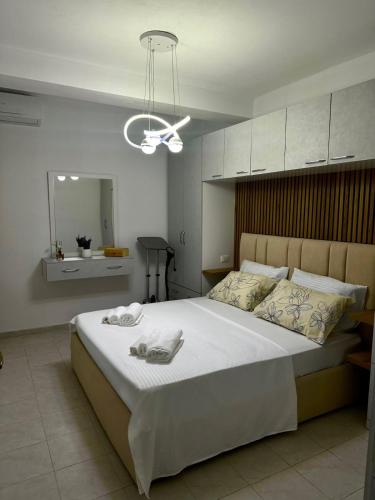 a bedroom with a large bed with two towels on it at Hill Escape Durres Vollga Apartment in Durrës