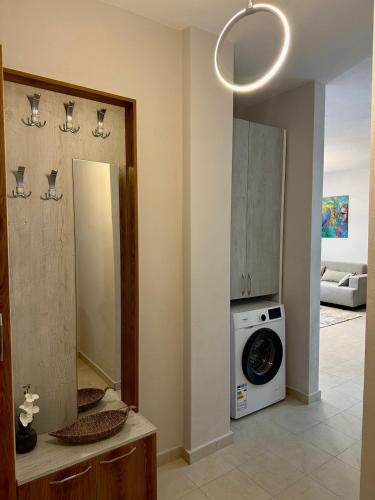 a bathroom with a washing machine and a mirror at Hill Escape Durres Vollga Apartment in Durrës