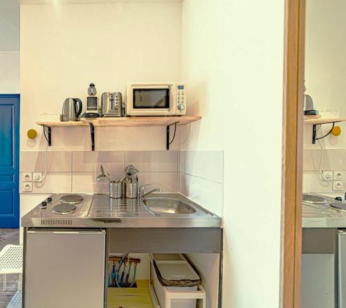 a small kitchen with a sink and a microwave at Le Nid de Perrache Comfortable and Stylish Studio in Lyon