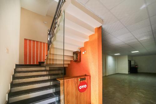 a hallway with stairs and a stop sign on a wall at Hotel O Swastik in Bhopal