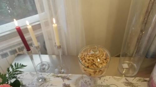 a table with three candles and a vase with pasta at Hotel Petit in Silvi Marina