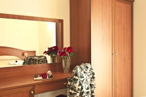 a bedroom with a mirror and a vase of flowers at Agriturismo Fasano in Cassano delle Murge