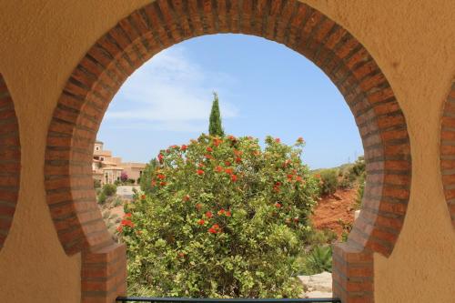 an archway in a building with a tree with red flowers at Casa Pia in Turre