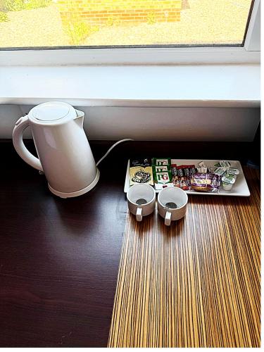 a table with a coffee pot and a box of food at Simplystay Lincoln Road in Skegness
