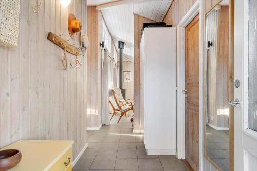 a hallway with a white refrigerator and a chair at 1129-Ringkobing-Irisvej-11 in Nørby