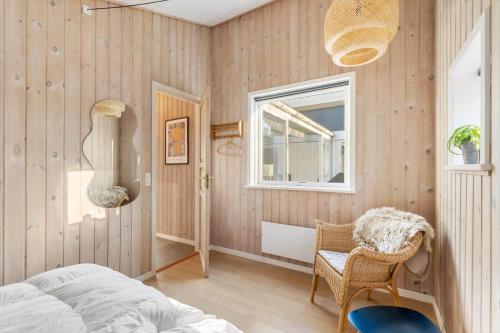 a bedroom with wooden walls and a bed and a window at 1129-Ringkobing-Irisvej-11 in Nørby
