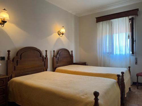 a bedroom with two beds and a window at Residencial Deu-La-Deu by Hotel Dom Afonso in Monção