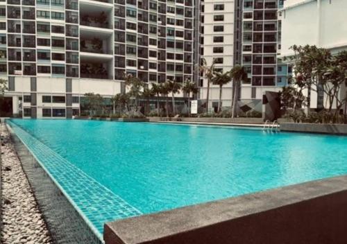 a large blue swimming pool in front of a building at I City Prefect Homestay in Shah Alam