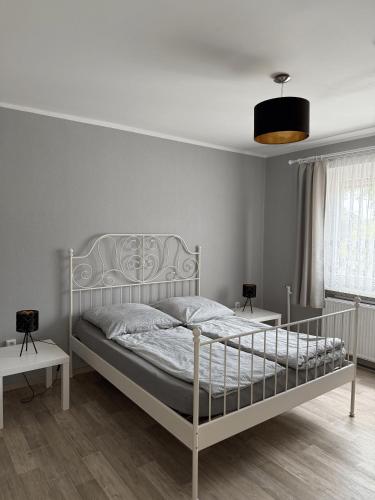 a bedroom with a white bed and two tables at Haus zur Sonne in Märkisch Buchholz