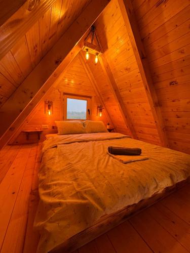 a bed in a wooden room in a attic at Summit chalets TL in Žabljak
