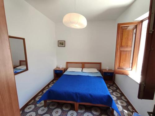 a bedroom with a blue bed and a mirror at Eoliando Case per Vacanze - Lipari Mare in Lipari
