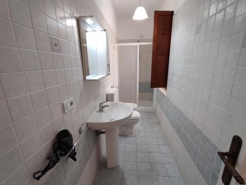 a white bathroom with a sink and a toilet at Eoliando Case per Vacanze - Lipari Mare in Lipari
