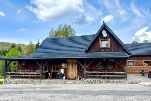a large wooden cabin with a black roof at Wellness Chata Chmaroška - Telgárt Resort in Telgárt