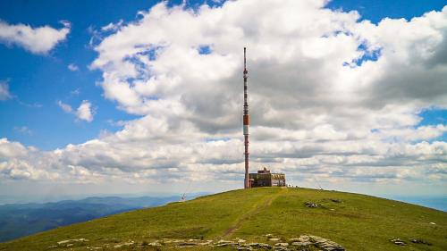 a pole on top of a hill with a tower on it at Wellness Chata Chmaroška - Telgárt Resort in Telgárt