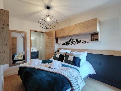 a bedroom with a large bed and a chandelier at Homency - Résidence Parenthese A28 in L'Alpe-d'Huez