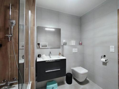 a white bathroom with a sink and a toilet at Homency - Résidence Parenthese A28 in L'Alpe-d'Huez