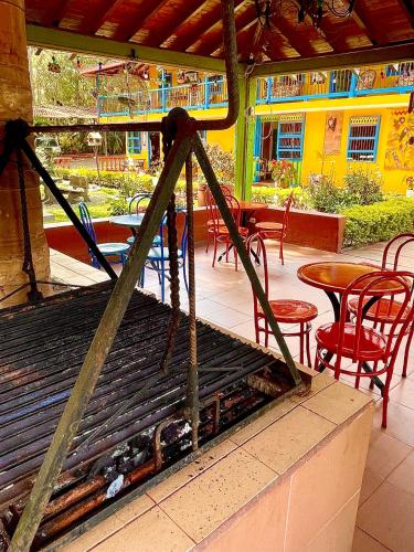 a grill in a restaurant with tables and chairs at Kampanario - Casa Hotel Jericó in Jericó