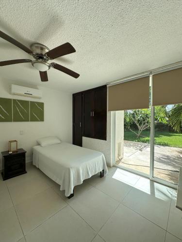 a bedroom with a bed and a ceiling fan at Cozy Apartment in Cancun in Cancún