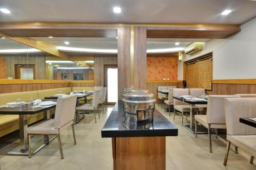 a dining room with tables and chairs in a restaurant at Townhouse Coastal Grand Hotels and Resorts in Coimbatore