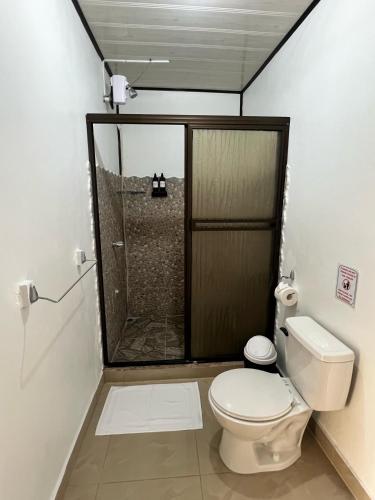 a bathroom with a toilet and a shower at Hotel Angsa River View Tortuguero in Tortuguero