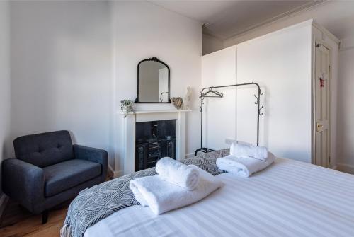 una camera con letto, sedia e specchio di Spacious 5BR House in Central Derby - Near Amenities a Derby