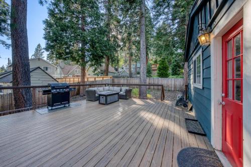 a deck with a couch and a grill on a house at Tahoe City Gem Pet Friendly Yard Walk to Beach in Tahoe City