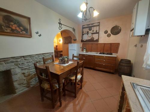 a kitchen with a wooden table and chairs and a refrigerator at Fattoria Antognoni in Reggello