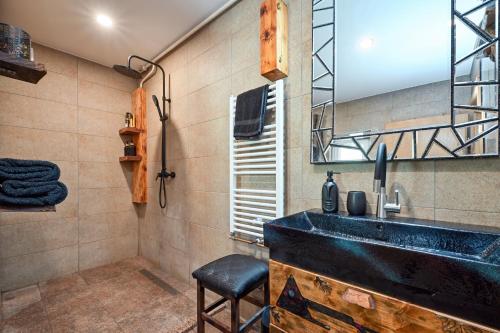 a bathroom with a black sink and a mirror at Chill House Keti in Kuzminec-Veternički