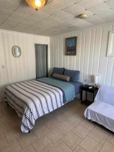 a bedroom with a bed and a bedskirtspectspectssenalsenalsenalsenalsenal at North Beach Motel in Hampton
