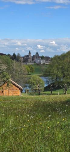 un prato con un lago sullo sfondo di Hôtel Restaurant du Lac a Camps